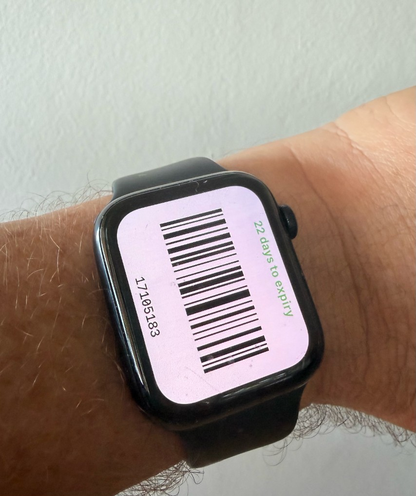 Apple Watch on a wrist showing a full-screen barcode with the ticket number and days to expiry along the edges